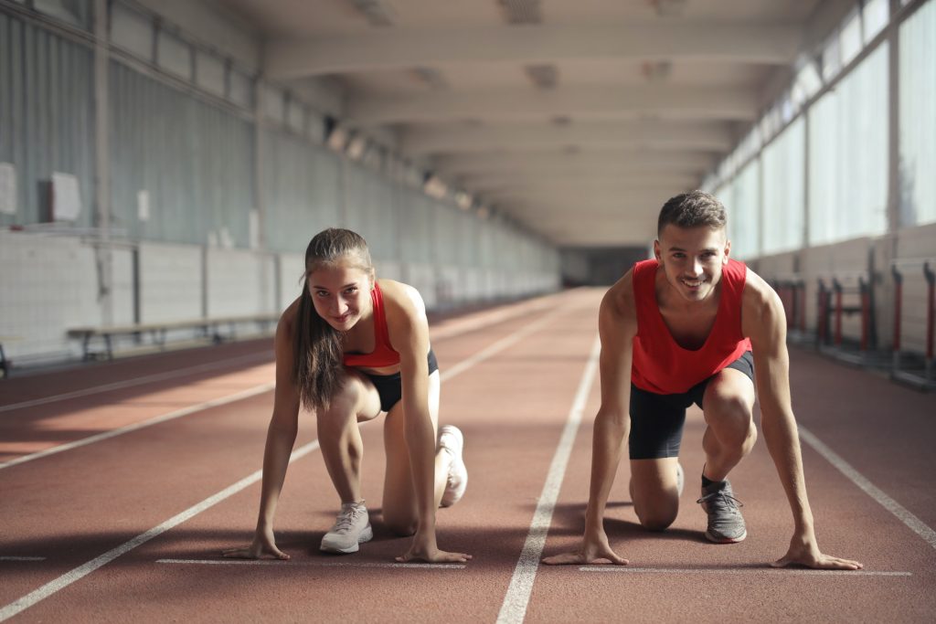 Female and male runners in starting positions. Photo by Andrea Piacquadio from Pexels
