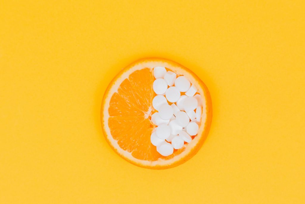 Vitamin C pills and orange