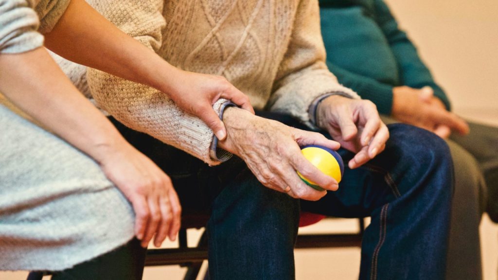 Woman holding an old man's hand